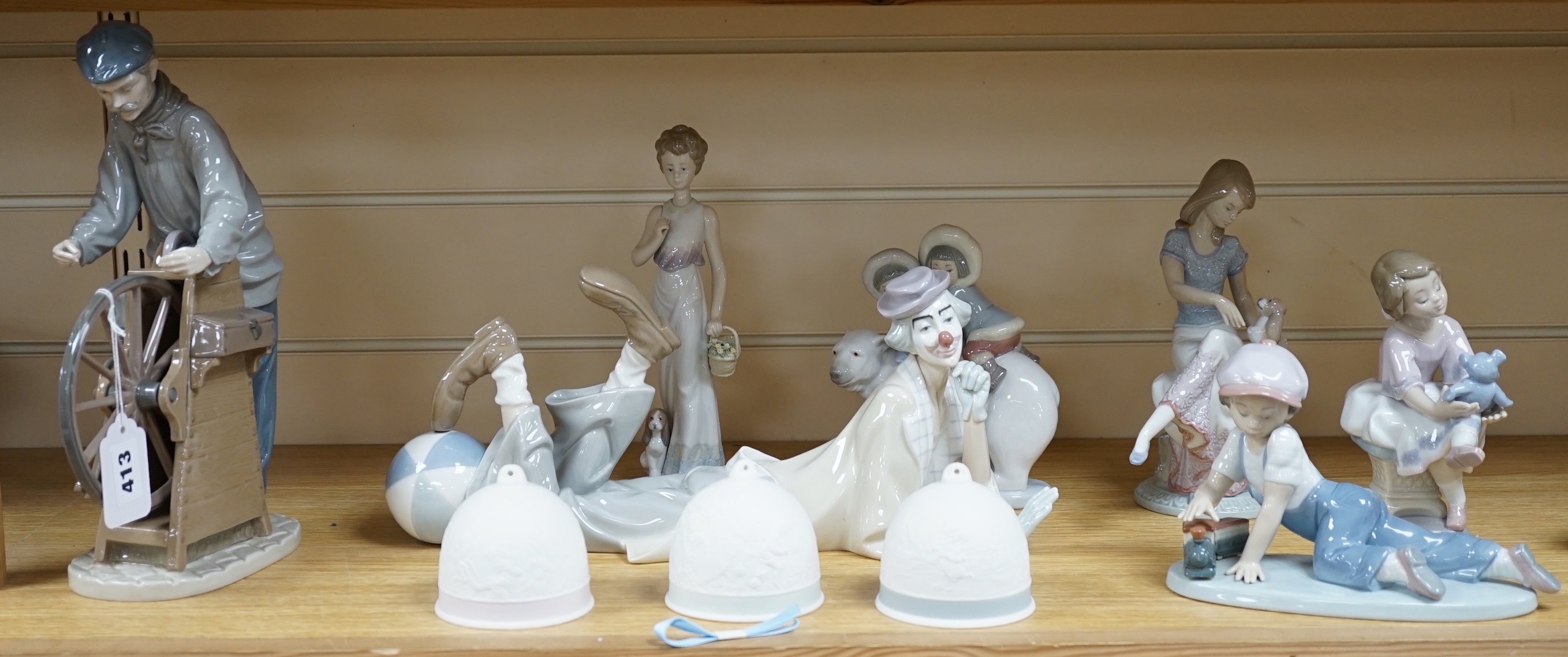 Seven Lladro figures including a clown together with three Lladro bells, the clown 37cm wide